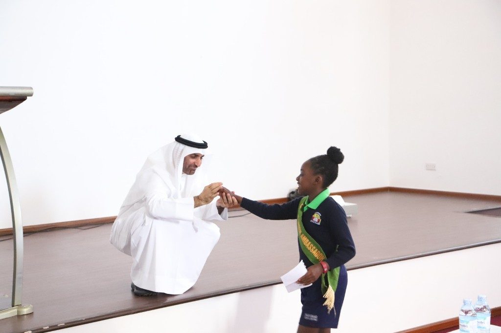 Young Green Ambassador greeted by a visiting dignitary at a formal ceremony