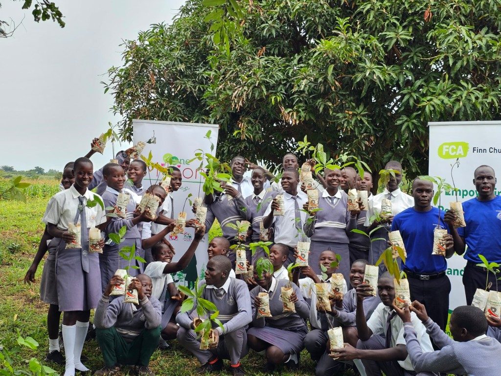 School pupils holding seedlings during a One Million Trees community planting day